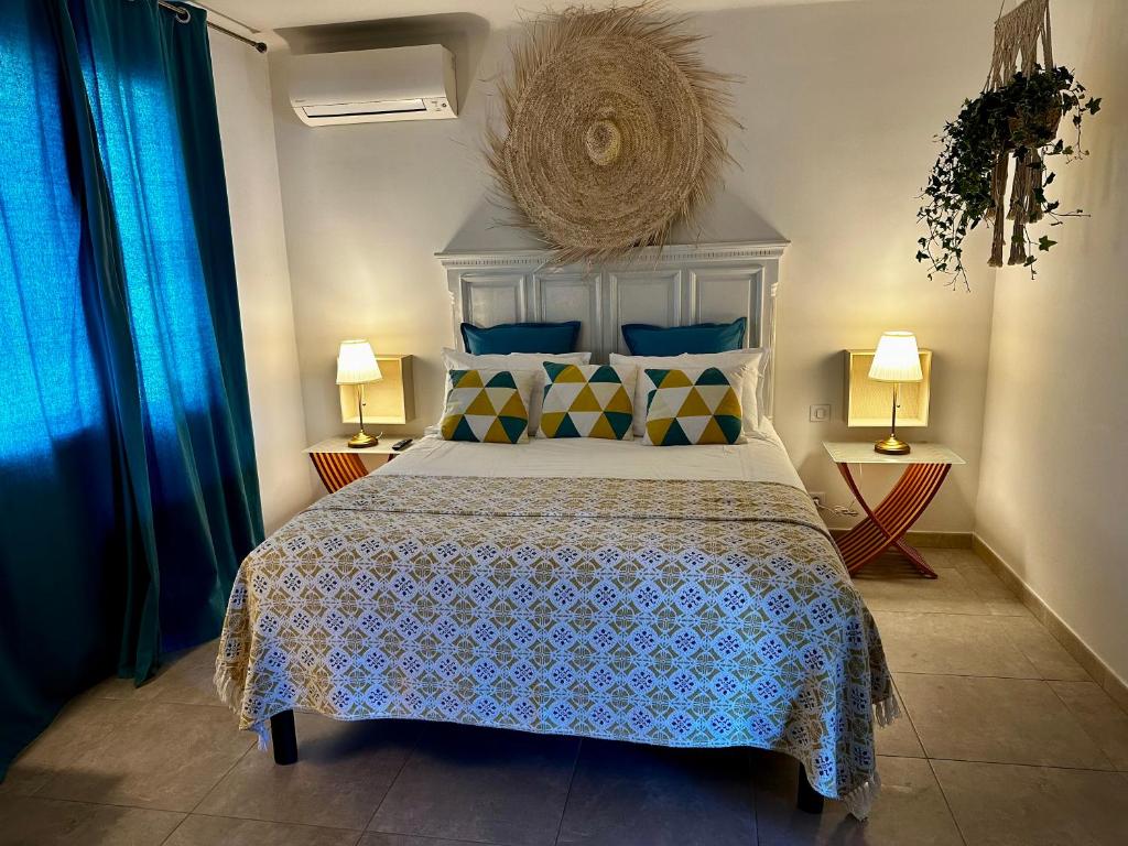 a bedroom with a bed with a blue bedspread and two lamps at CASSIS VILLAGE Options Parking and Baby in Cassis
