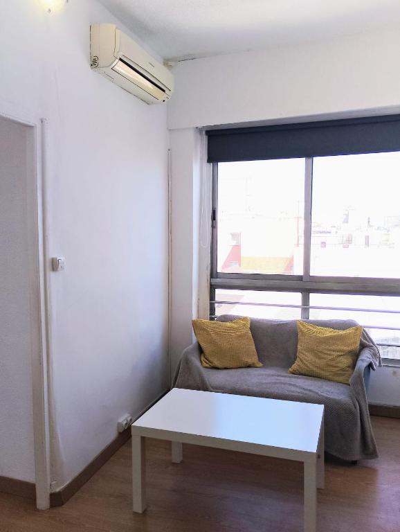 sala de estar con sofá y ventana en Apartamento Chamberí, en Madrid