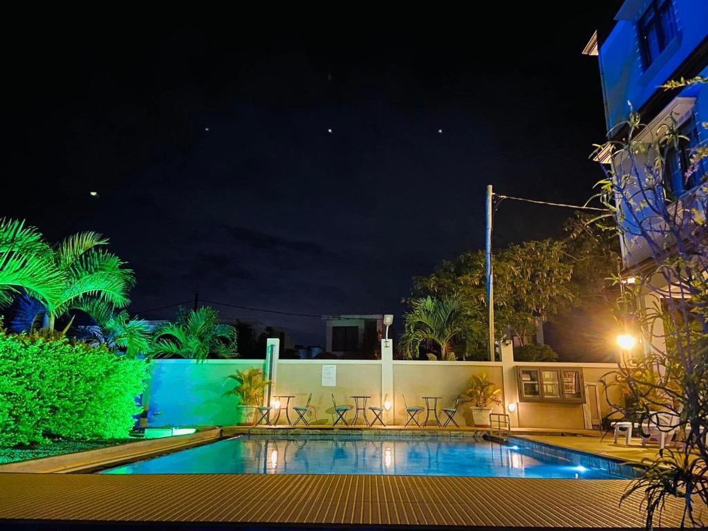 a swimming pool at night with tables and chairs at Morison Bay in Grand-Baie
