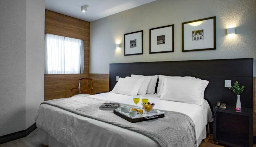 a bedroom with a large bed with a tray on it at Cambirela Hotel in Florianópolis