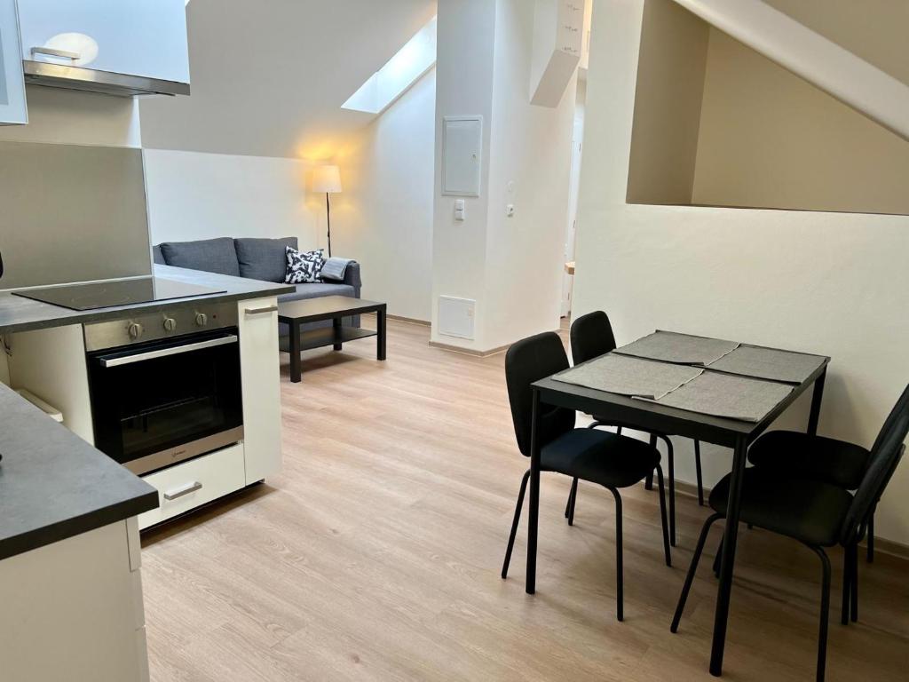 a kitchen and living room with a table and chairs at Sleep&Go in Prague