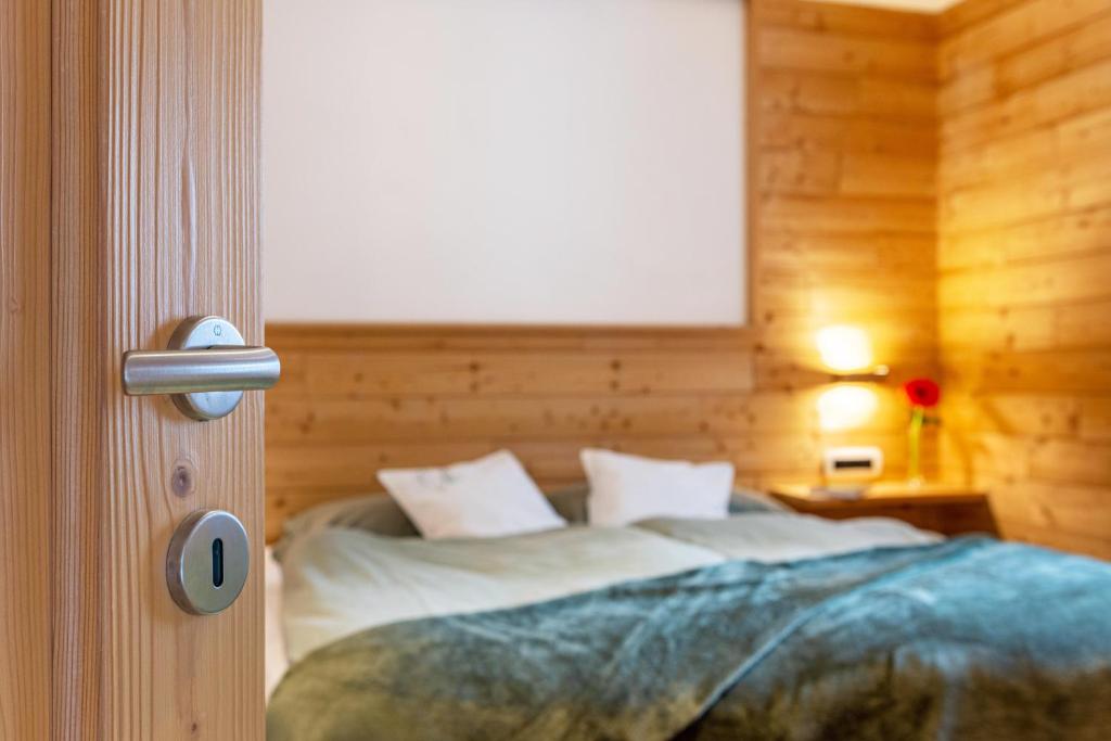 una camera da letto con letto in una camera in legno di Ciasa Majonade Pozza di Fassa tipo1 a Pozza di Fassa