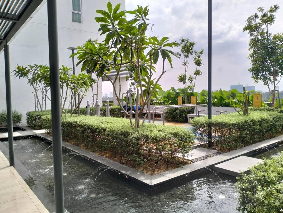 Elle offre une vue sur un jardin avec des arbres et de l'eau. dans l'établissement Plaza @ Kelana Jaya 2 Bedroom House NEW 2024!, à Petaling Jaya