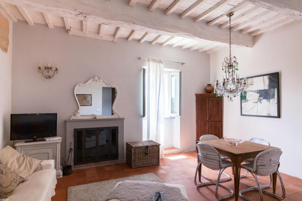 a living room with a table and a fireplace at Casa Breccia in Compignano