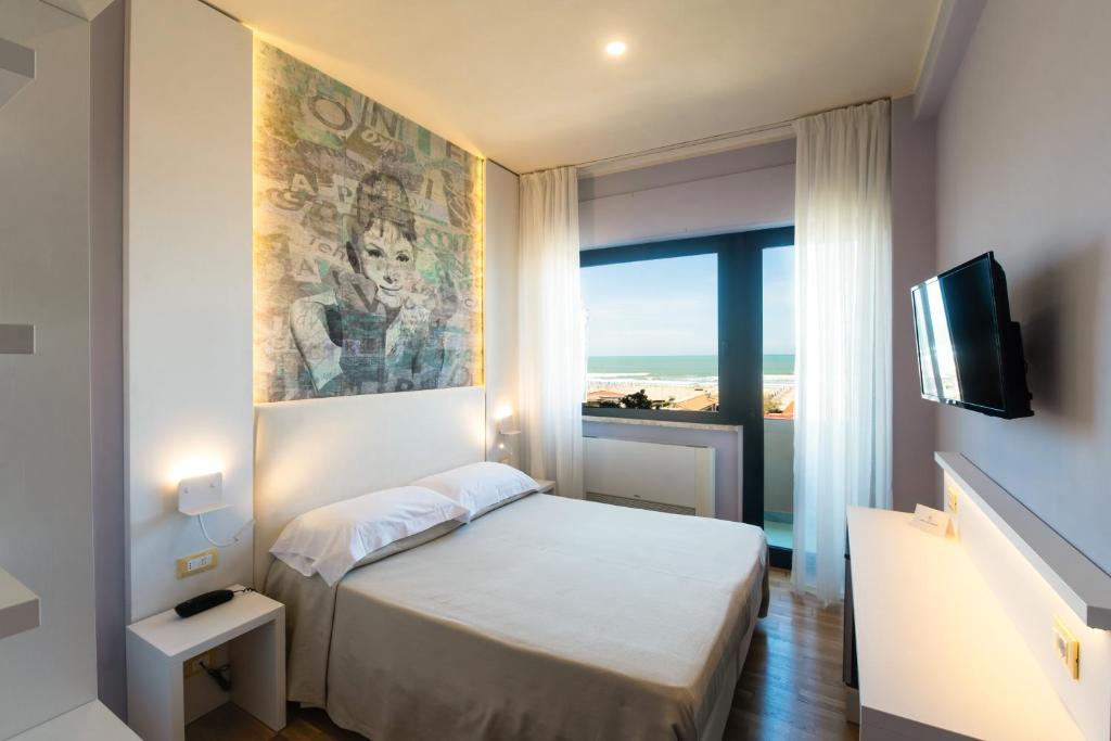 een kleine slaapkamer met een bed en een televisie bij Hotel San Francisco in Viareggio