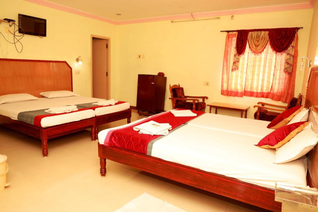 Un pat sau paturi într-o cameră la KG Grand Inn
