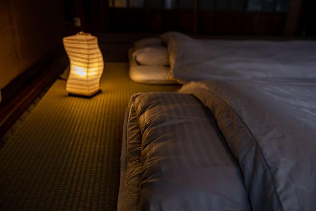 Una cama o camas en una habitación de アップスタイル大垣ー明治から時を刻む古民家。