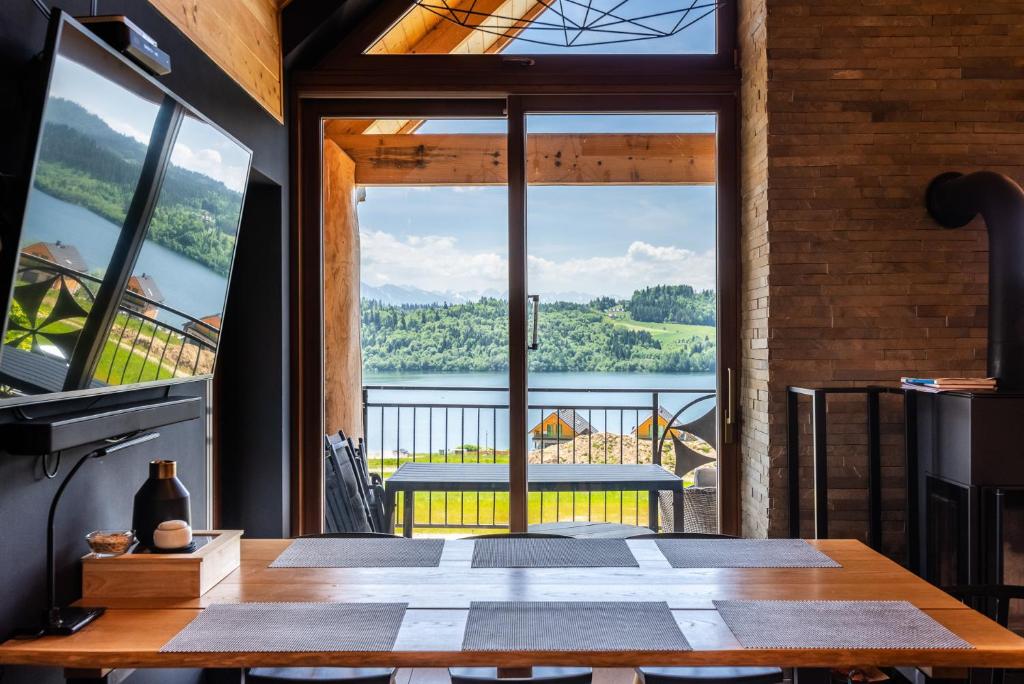 a room with a large window with a view of a lake at Stylchyn Park-Apartament z Widokiem na Jezioro Czorsztyńskie - by Upstairs in Kluszkowce
