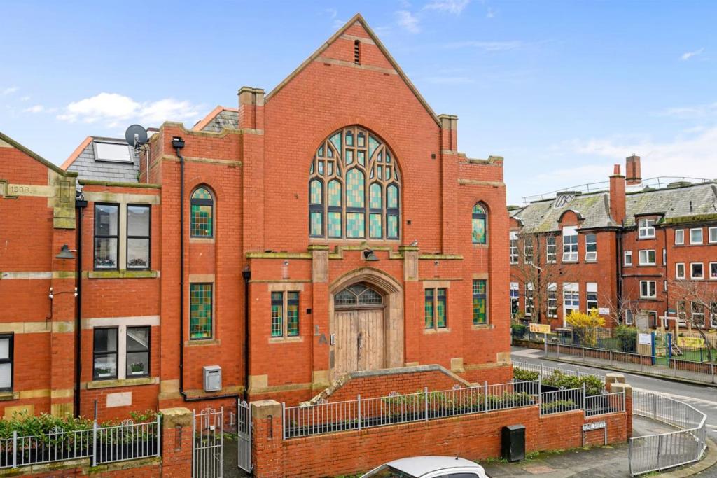 a large red brick building with a large door at Luna Church Conversion 1 in Blackpool