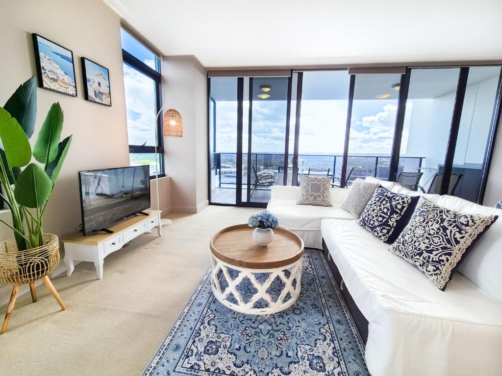 sala de estar con sofá blanco y TV en Holiday Style 2 BRStudy Apartment in Olympic Park, en Sídney