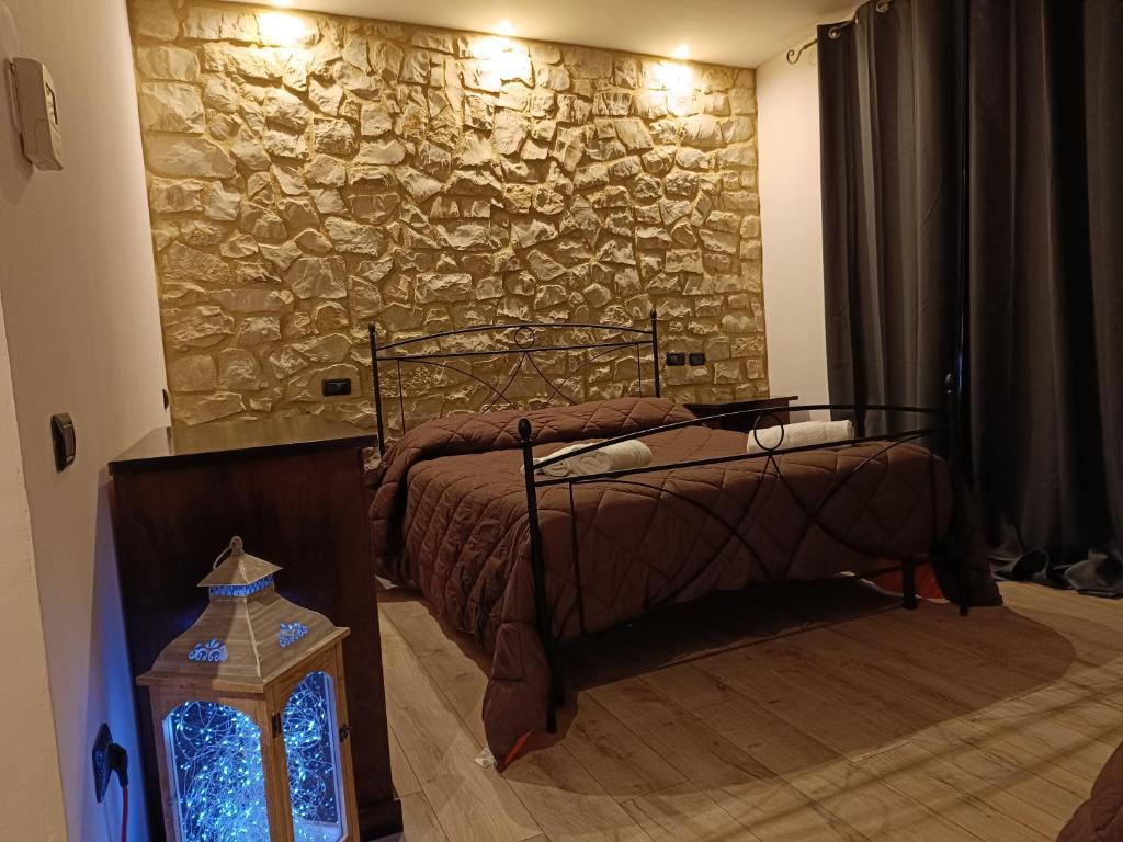 a bedroom with two beds and a stone wall at Il Casale Di Ginetto in Cascia
