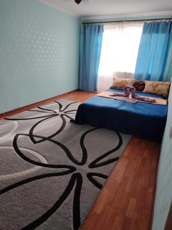 - une chambre avec un lit et un tapis dans les arbres dans l'établissement 1ком кв центр вокзал, à Uralsk