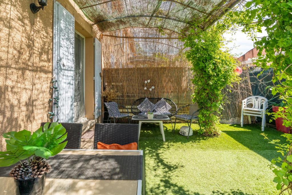 une terrasse avec une tonnelle, une table et des chaises dans l'établissement Rayonnante maison Mont Ventoux, à Villes-sur-Auzon