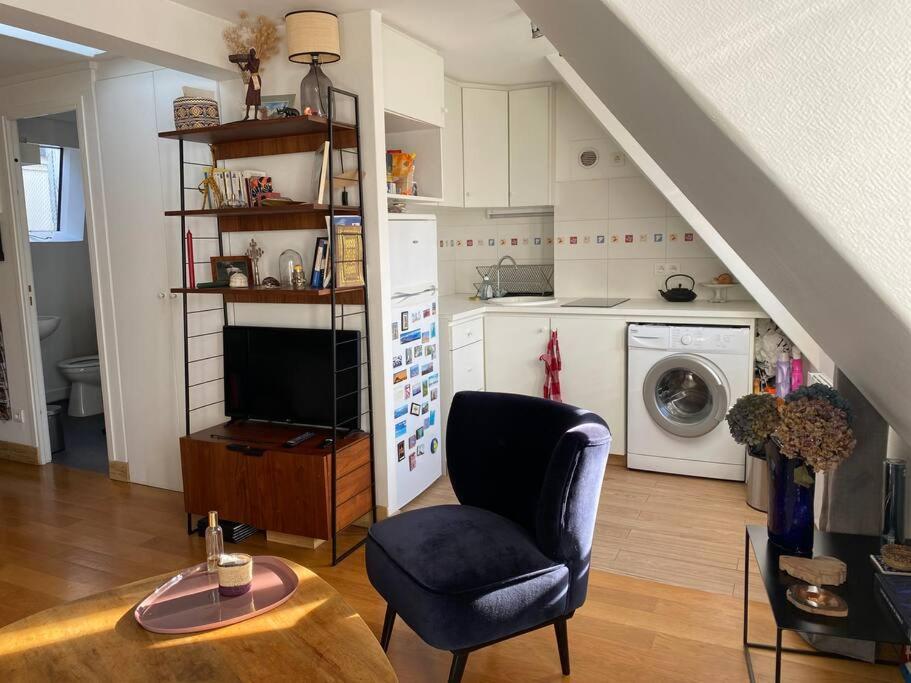 Il comprend un salon doté d'un canapé et d'une chaise ainsi qu'une cuisine. dans l'établissement Charmant studio lumineux en plein centre de Paris, à Paris