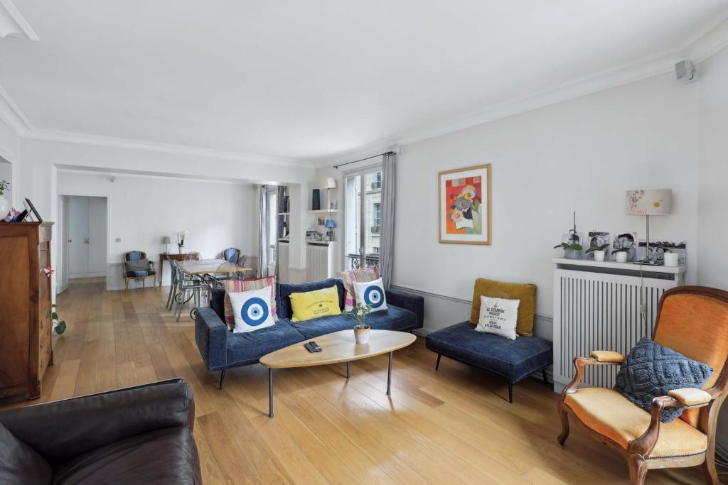 un salon avec des canapés bleus et une table dans l'établissement Grand appart 140m² à deux pas de la Tour Eiffel, à Paris