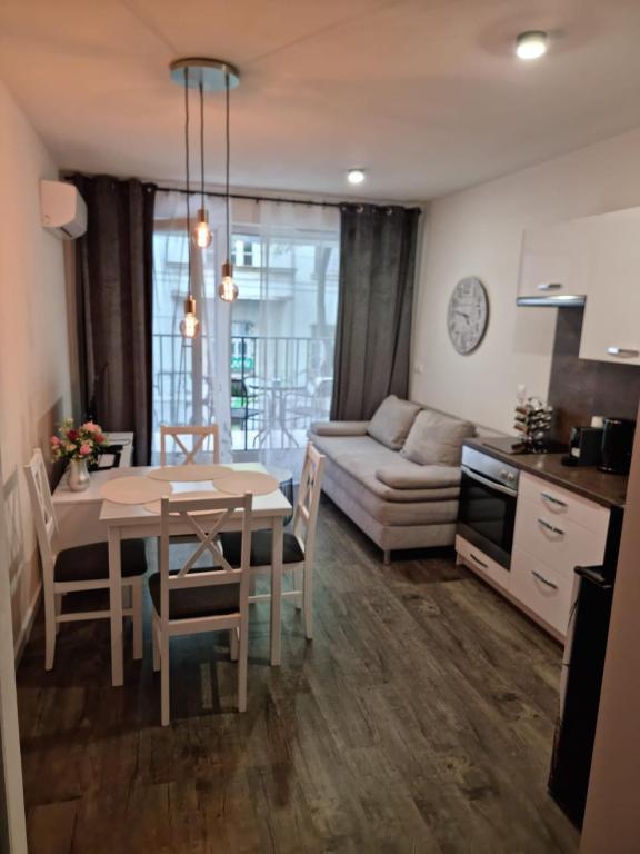 a kitchen and living room with a table and a couch at Apartman - Centrum in Bratislava