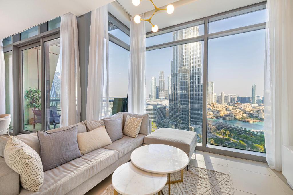 a living room with a couch and a large window at Burj Khalifa & Fountain Views, Exclusive Apartment in Burj Vista Building in Dubai
