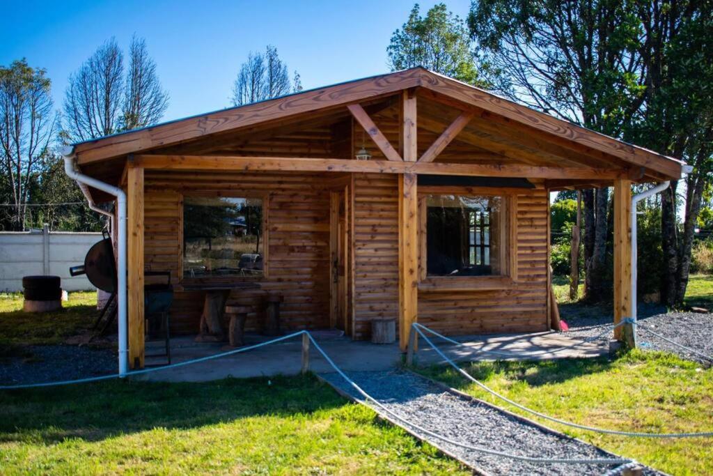 a wooden cabin with a roof on the grass at •Cabañas Patagonia• in Puerto Montt