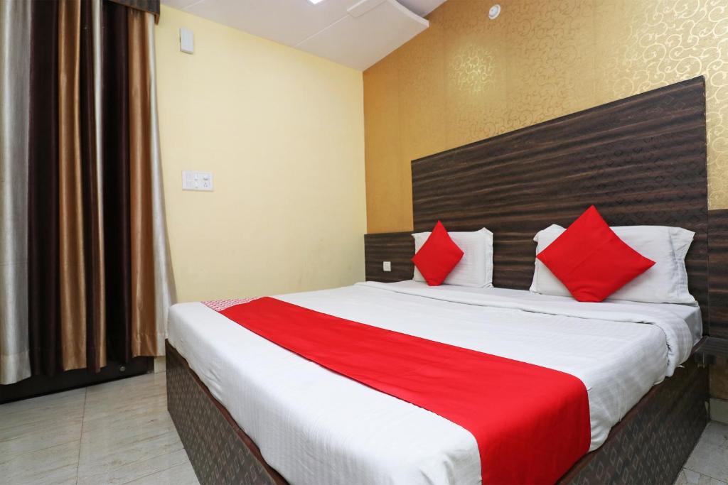 a bedroom with a large bed with red pillows at Super OYO Flagship Hotel Park Avenue in Lucknow