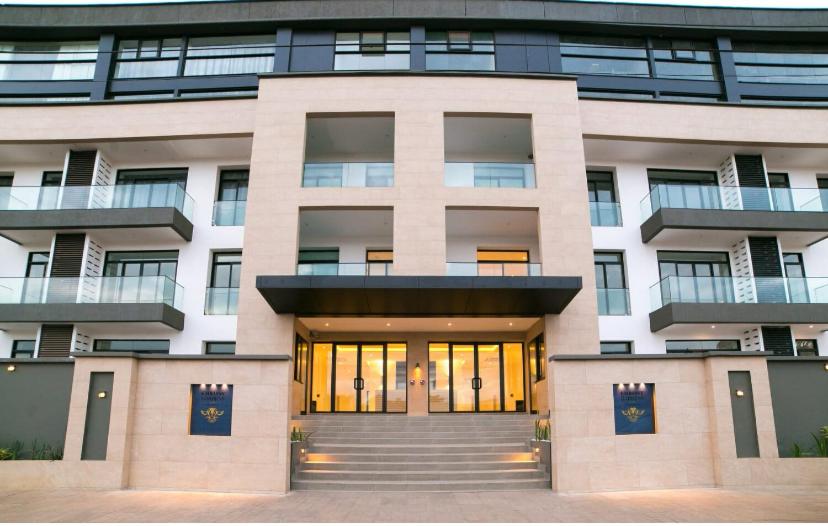 a large building with a front door in front at Embassy Gardens Royal Suites Apartments in Accra