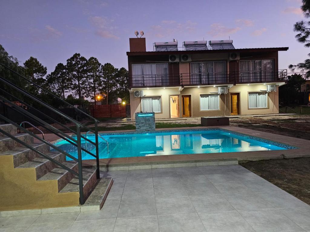 a house with a swimming pool in front of a house at Villa Termal Norte in Federación