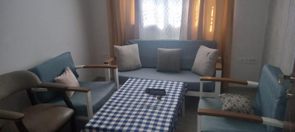a living room with a blue couch and two chairs at Dar Momo in Nabeul