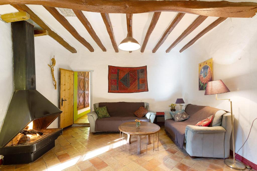 uma sala de estar com um sofá e uma lareira em Cal Malla petit em Artés
