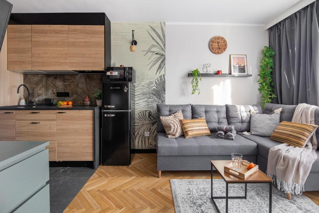 sala de estar con sofá gris y cocina en SuperApart Bruna 22, en Varsovia
