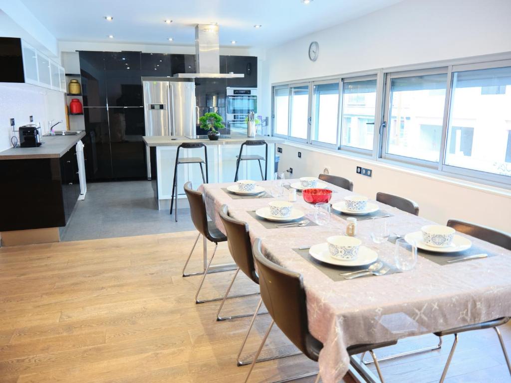 uma cozinha e sala de jantar com mesa e cadeiras em Spacieux appartement aux portes de Paris, parking gratuit em Bagnolet