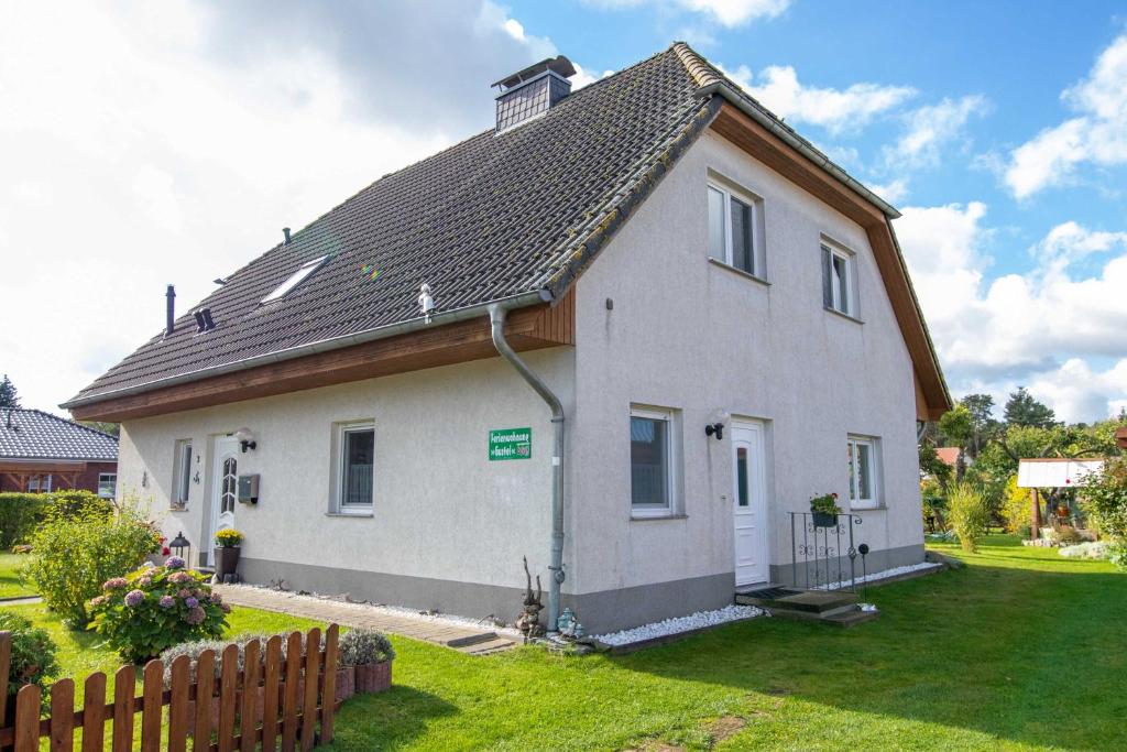 una casa blanca con una valla en un patio en Ferienwohnung Gustel, en Freest