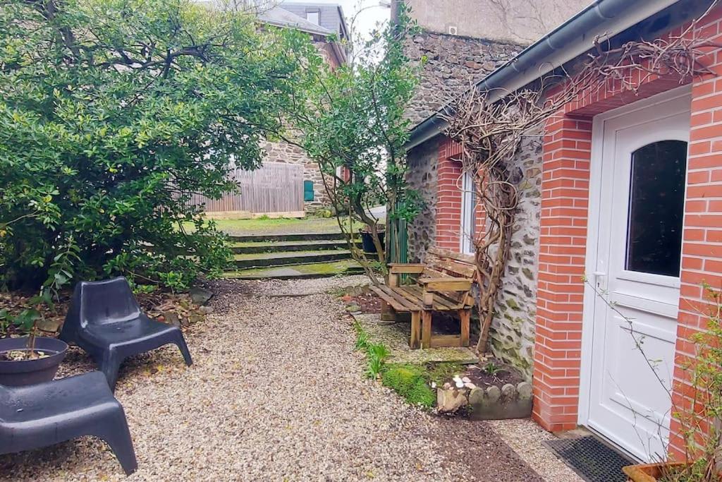 une cour avec un banc et un bâtiment dans l'établissement Maisonnette LA CORDE avec terrasse privée, à Granville