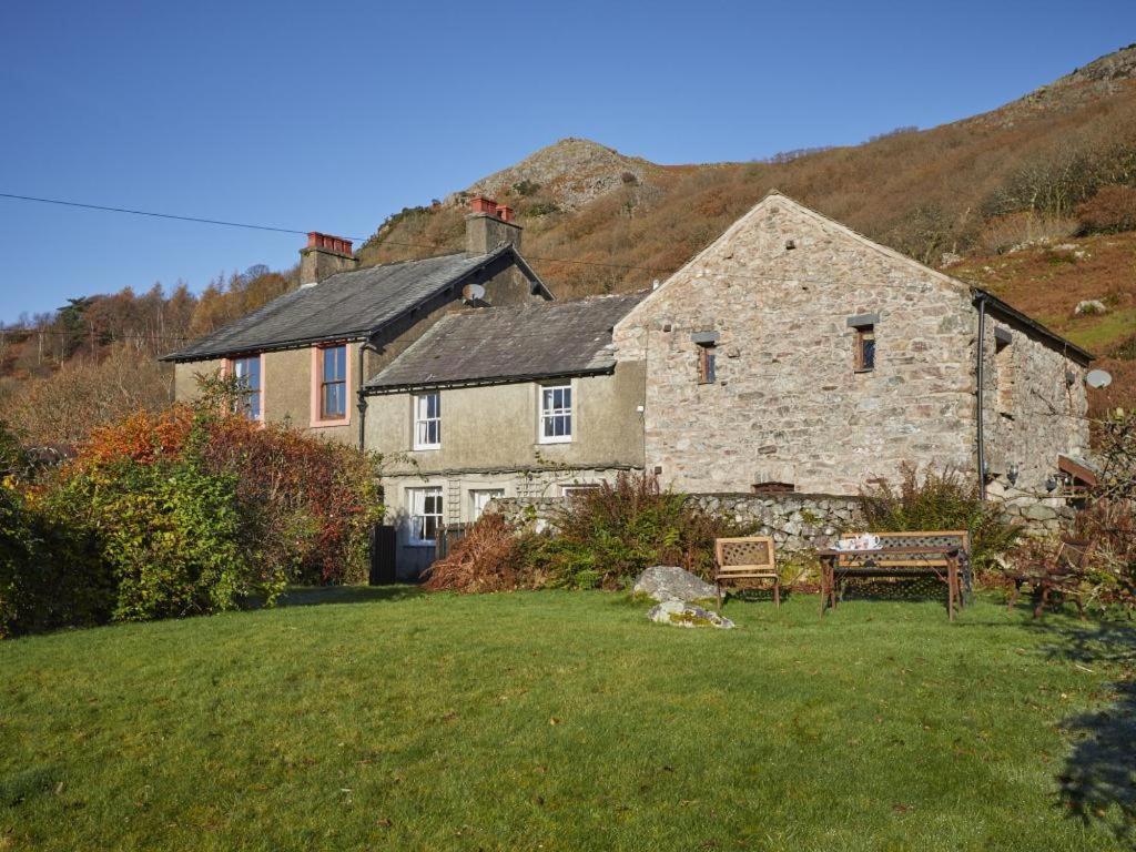 a large stone house with a bench in a yard at 3 bed in Eskdale SZ313 in Boot