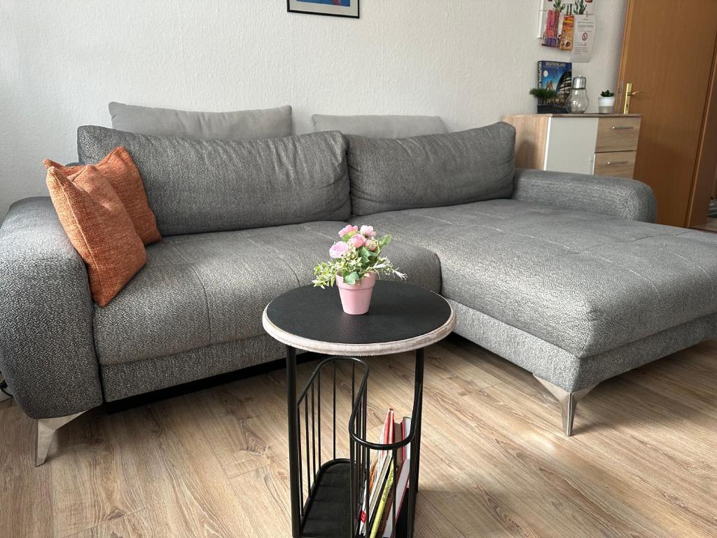 a living room with a gray couch with a table at Ferienwohnung Zeitz Appartment Moritzburg in Zeitz