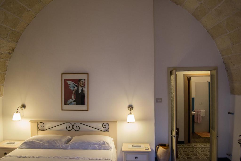 een slaapkamer met een bed met een boog erboven bij B&B a Casa della Nonna Uccia in Nardò