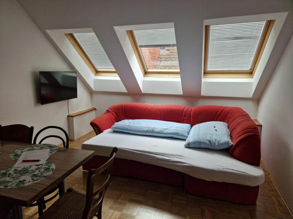 sypialnia z czerwoną kanapą w pokoju ze stołem w obiekcie Casa di Giovanni - Österreich w mieście Frohnleiten