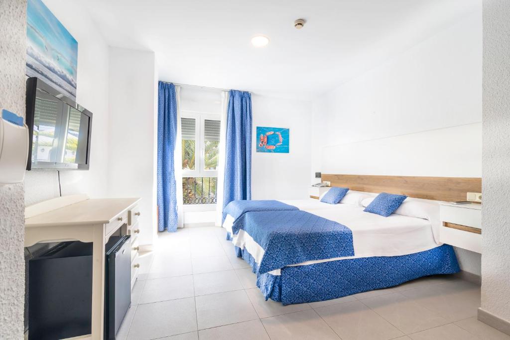 a hotel room with a bed and a television at Hotel Pozo del Duque II in Zahara de los Atunes