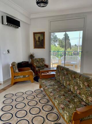 uma sala de estar com um sofá e uma cadeira em Appartement Pied Dans L'eau ! em Beni Khiar