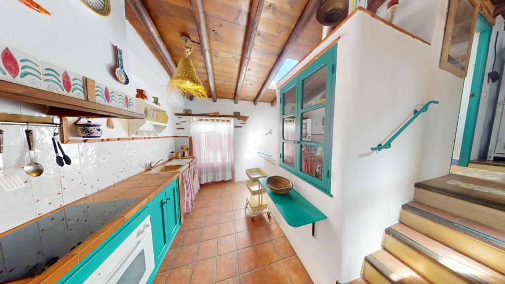 cocina con armarios verdes y techo de madera en La Apañaora, en Galaroza