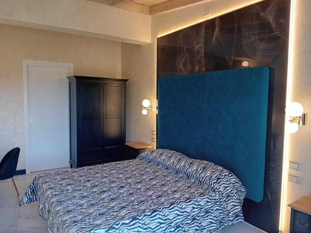 Schlafzimmer mit einem Bett mit blauer Wand in der Unterkunft angolo di paradiso in Formello