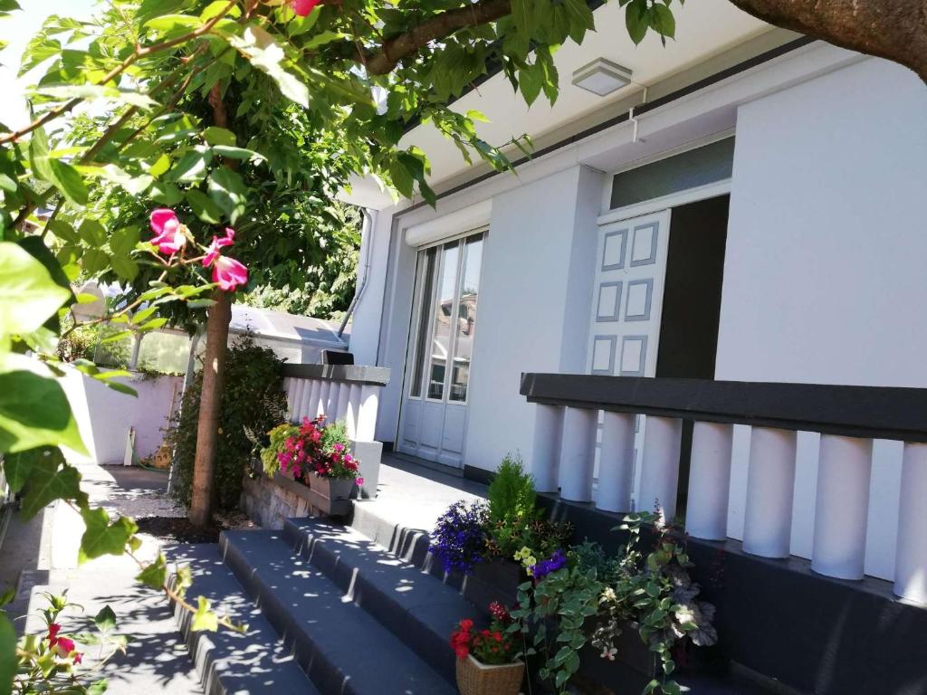 Ein Haus mit einem Blumenstrauß auf der Veranda. in der Unterkunft Chambre avec douche in Lourdes