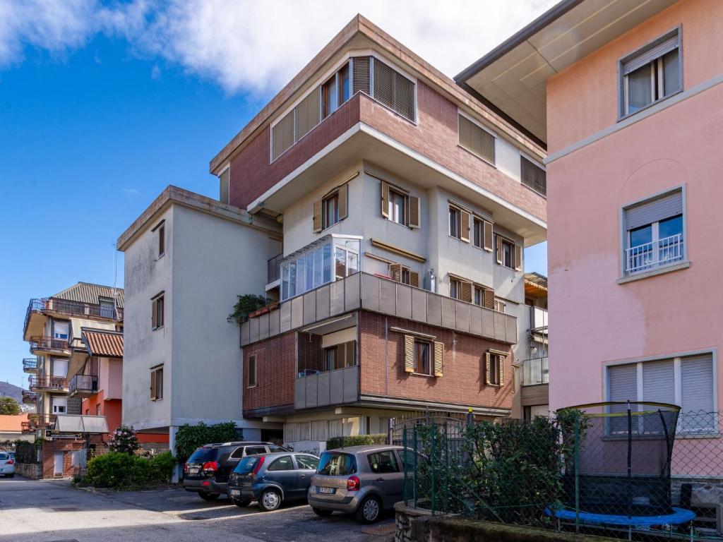 un immeuble d'appartements avec des voitures garées dans un parking dans l'établissement Apartment Giulia by Interhome, à Luino