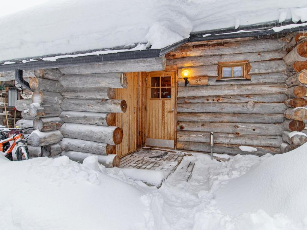 une cabane en rondins dans la neige avec une porte dans l'établissement Holiday Home Keidaskero b 9 by Interhome, à Pyhätunturi