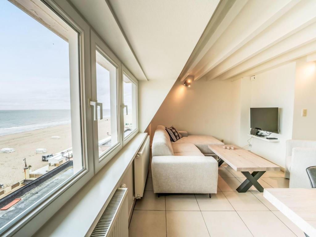 sala de estar con sofá y mesa en Apartment Koekoeksnest by Interhome, en De Haan