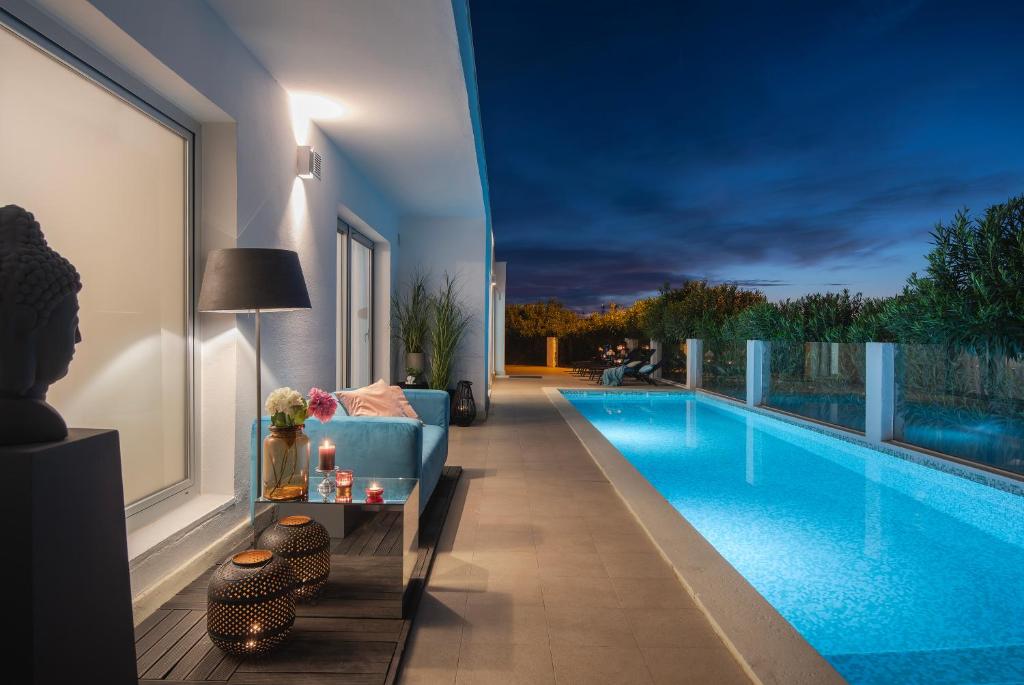 uma sala de estar com um sofá azul ao lado de uma piscina em Monvidal Residence - Adults Only em Pula