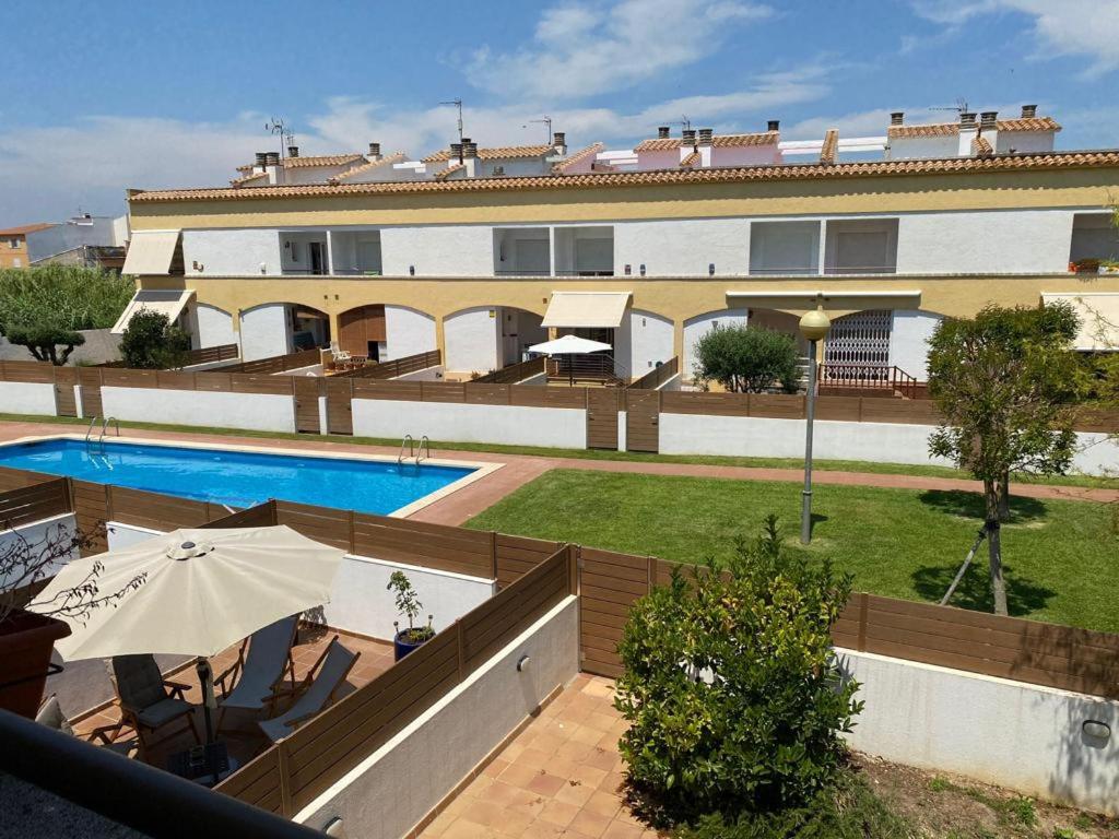 ein Hotel mit einem Pool und einem Gebäude in der Unterkunft Casa pareada con piscina in L'Escala