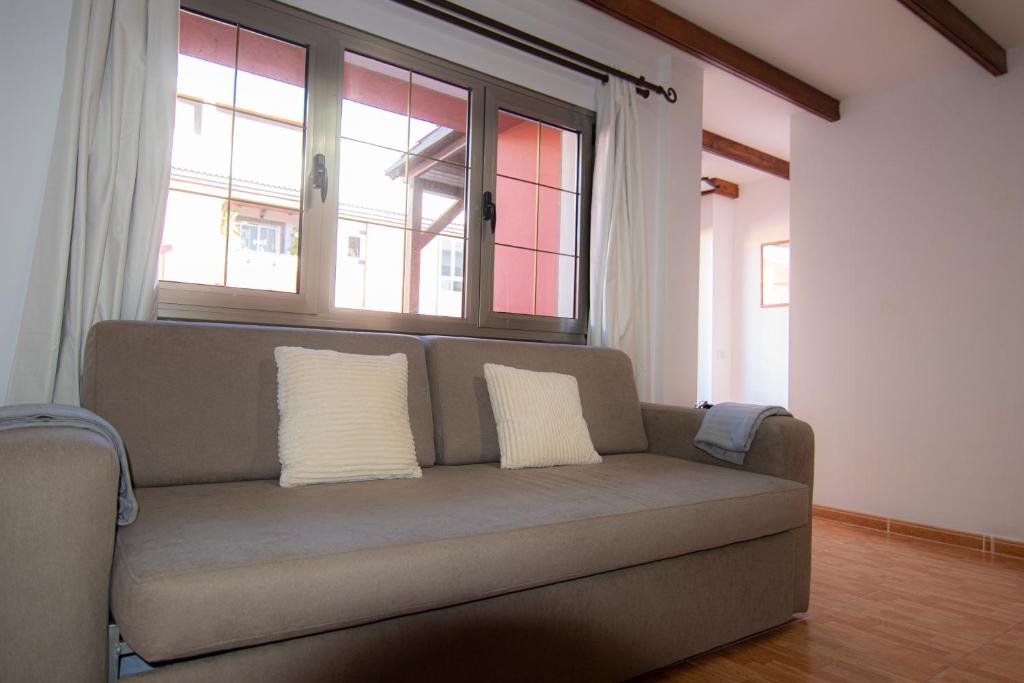 Villa Florymar في إيخينيو: أريكة في غرفة معيشة مع وسادتين عليها