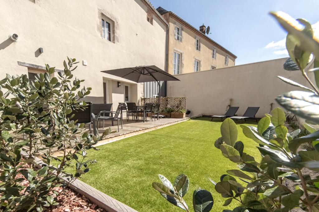 a backyard with a lawn with an umbrella at Le Clos de la Jouvence - Gite 4* à 15 minutes du Puy du Fou, 6 personnes in Saint-Laurent-sur-Sèvre