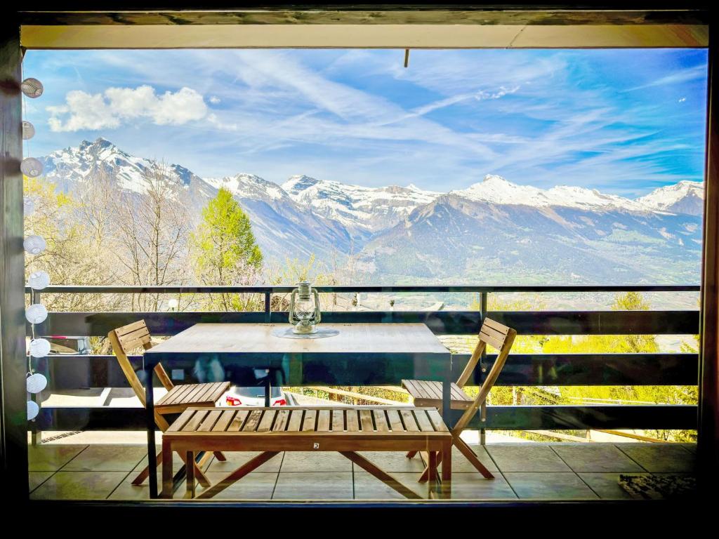 einen Tisch und Stühle auf einem Balkon mit Bergblick in der Unterkunft Apartment Swiss Alps view Aiglon H2 by Interhome in Nendaz