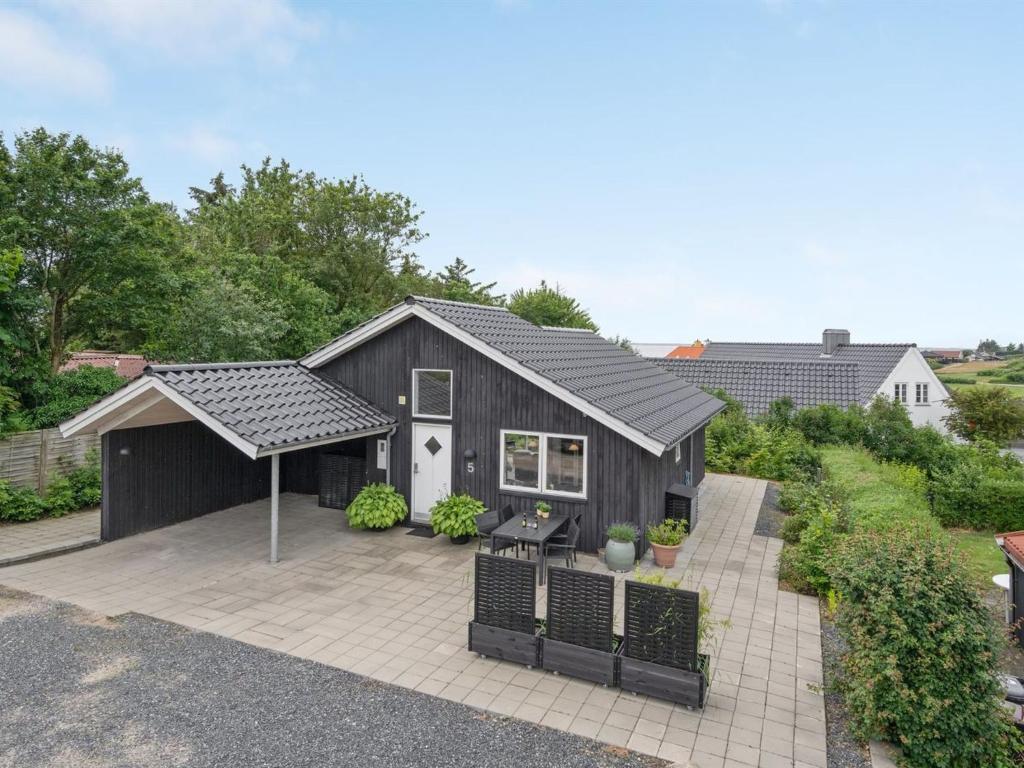 una casa con una casa negra con patio en Holiday Home Jörgen - all inclusive - 100m from the sea by Interhome, en Esbjerg