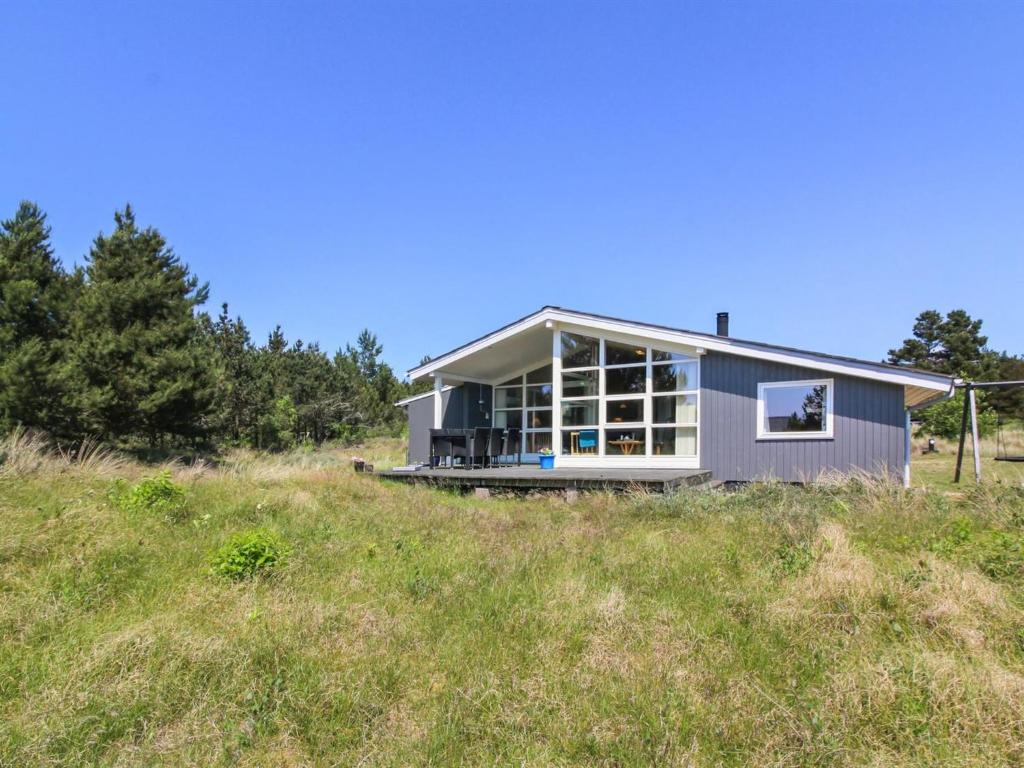 uma casa no topo de uma colina relvada em Holiday Home Nadia - all inclusive - 1-7km from the sea by Interhome em Blåvand